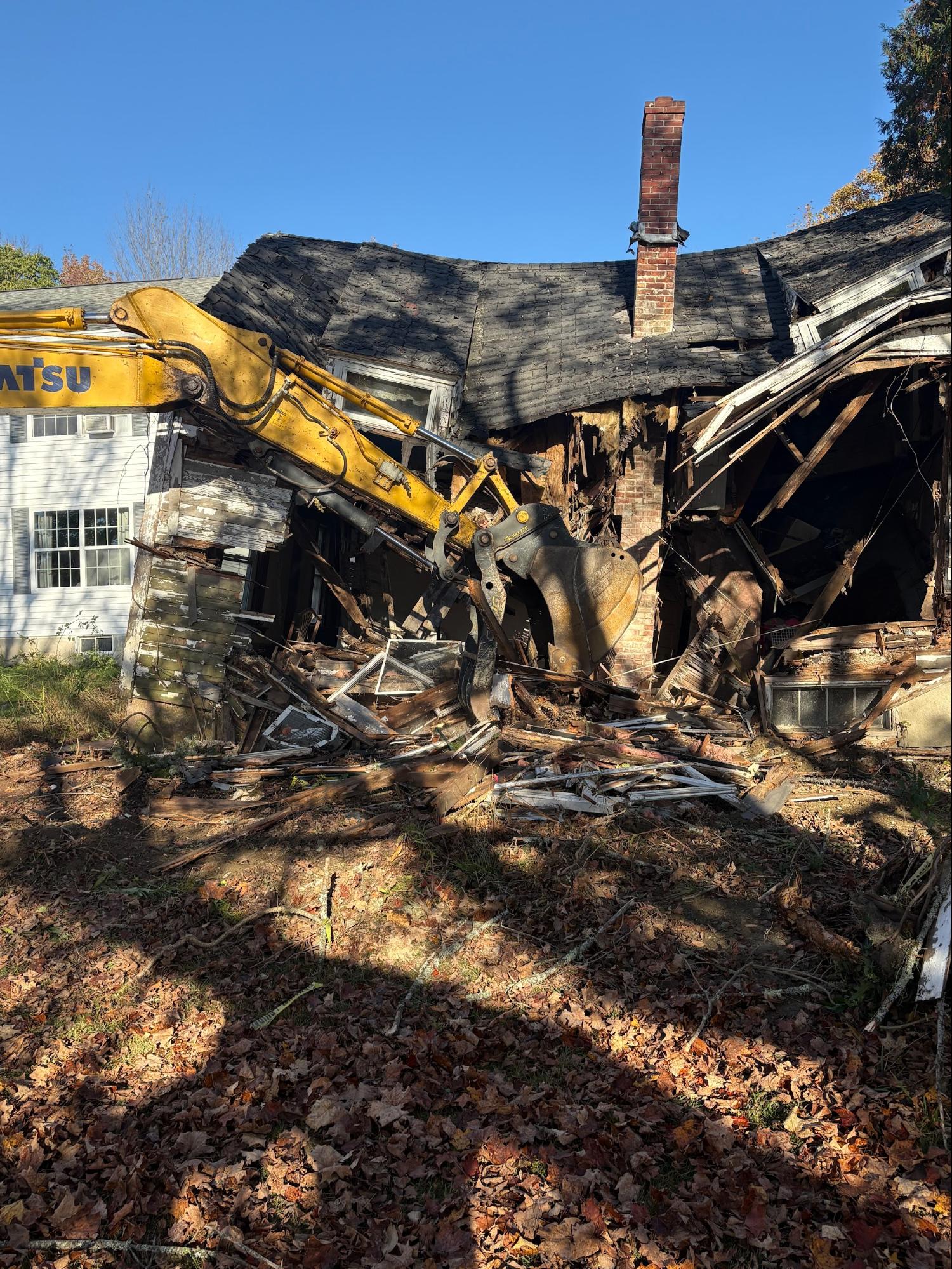 Excavator tearing down residential building