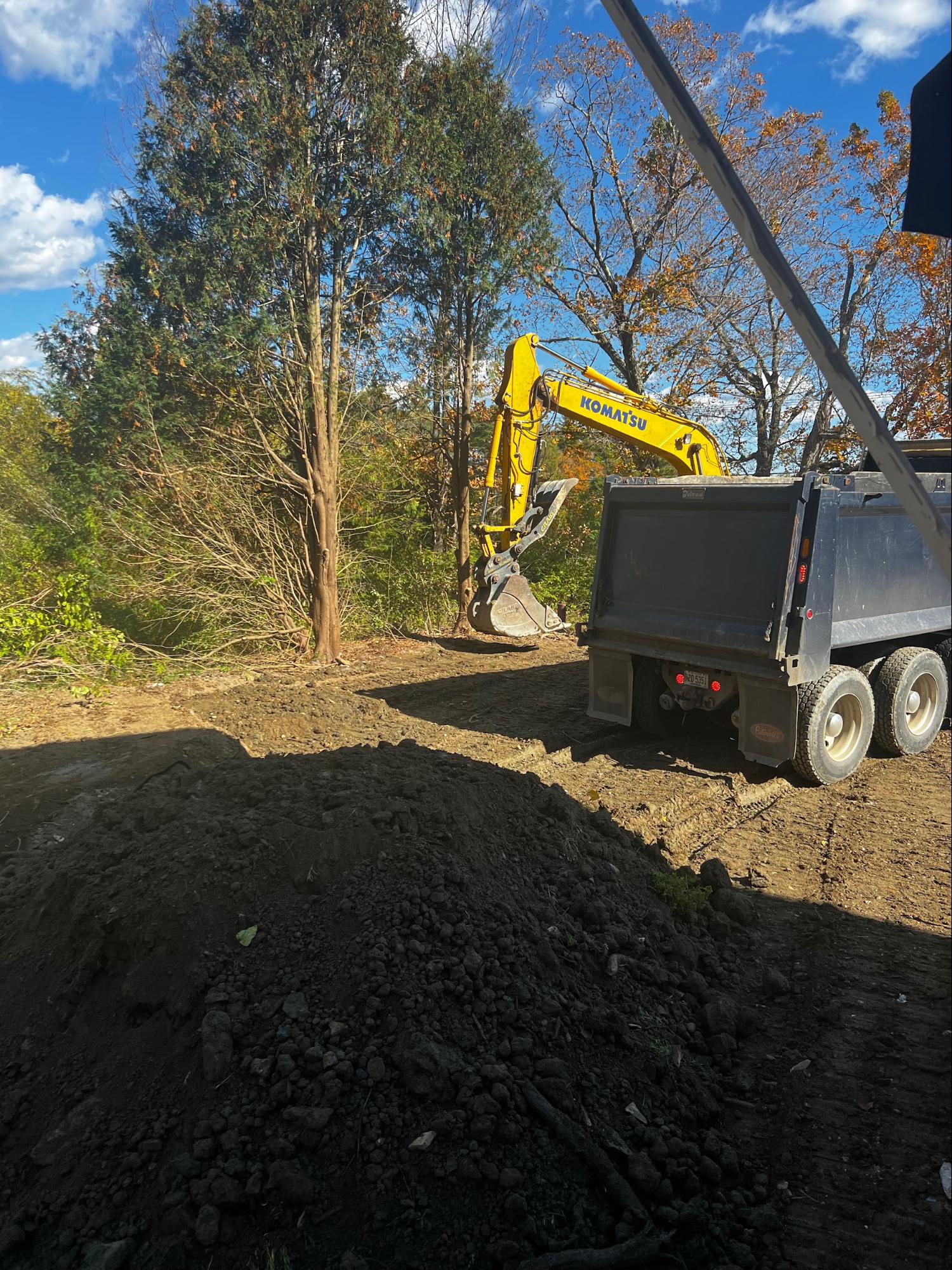 Excavator loading dump truck on site